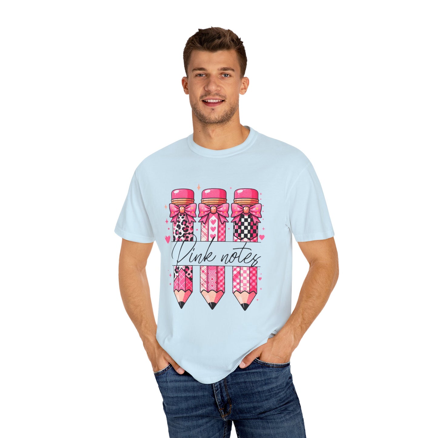 Man wearing a light blue t-shirt with pink pencils and bows design on a white background