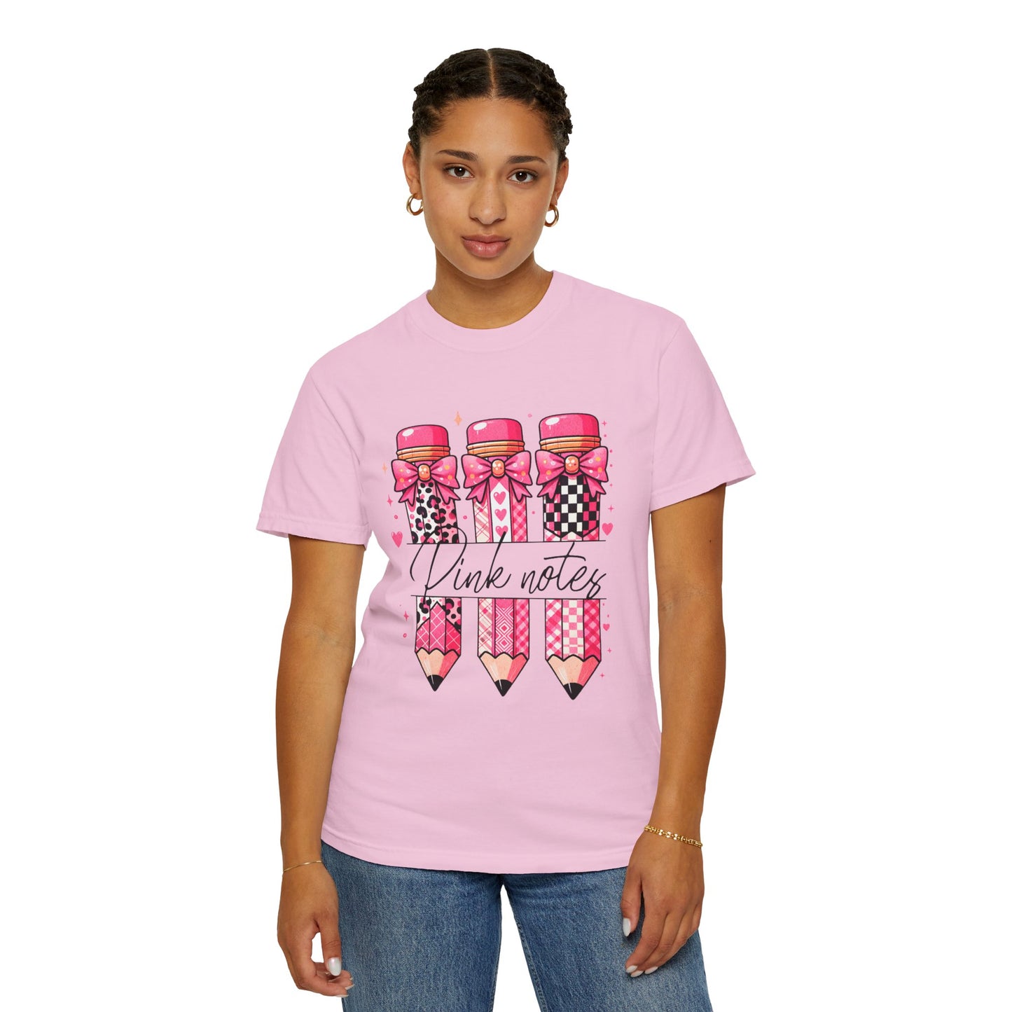 Person wearing a pink t-shirt with decorative pencils and text on a white background