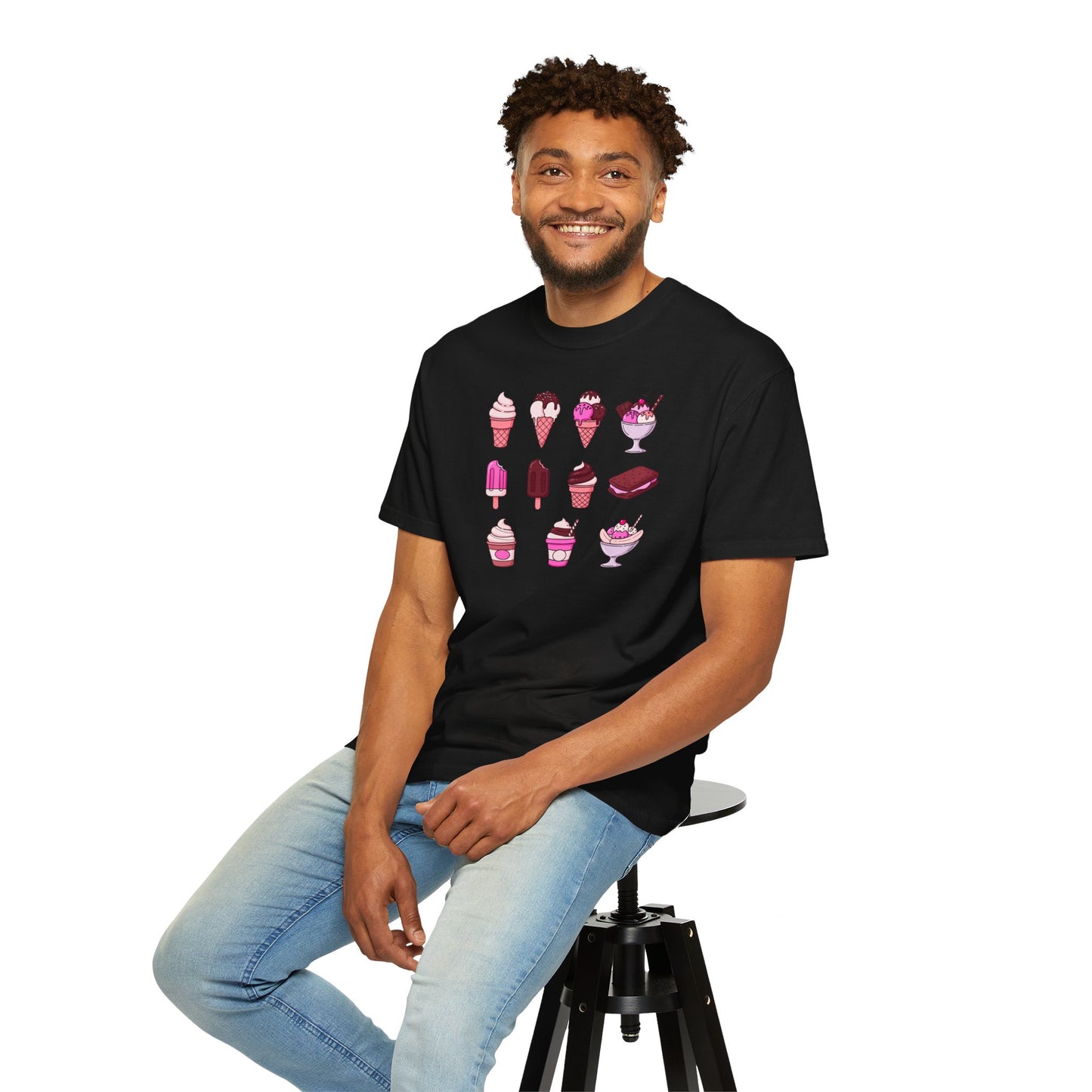 Man wearing a black t-shirt with ice cream graphics sitting on a stool against a white background
