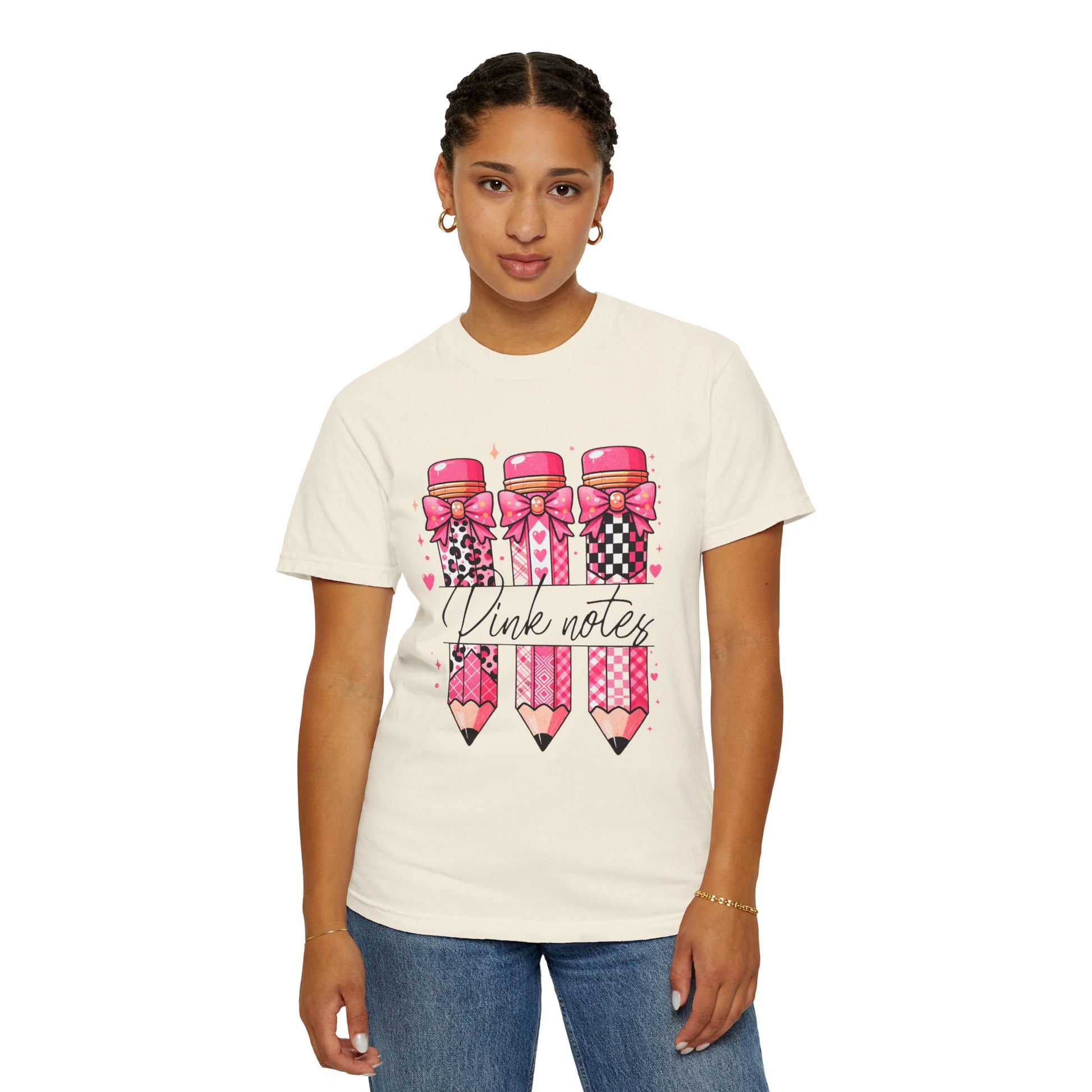 Person wearing a white t-shirt with pink and black pencil design and text on a white background
