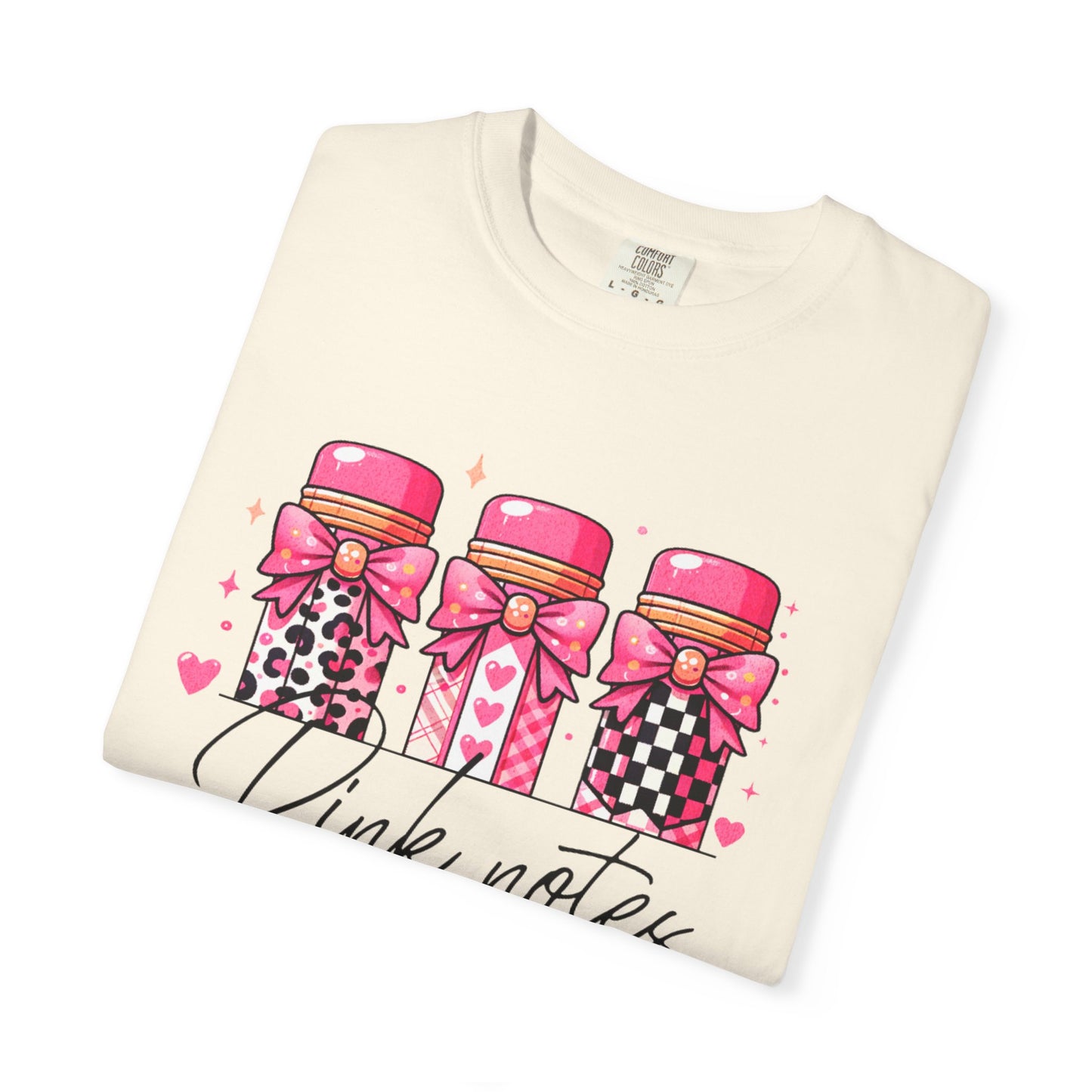 Folded t-shirt with pink notebook design on a white background