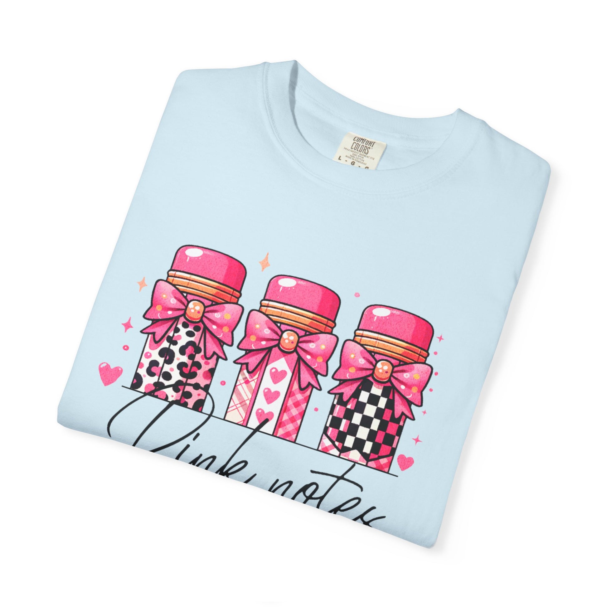 Light blue t-shirt with pink notebook design on a white background